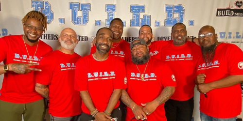 group of men wearing red shirts that read "BUILD"