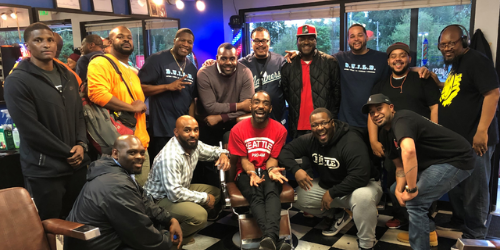 Group of men posing inside a barbershop